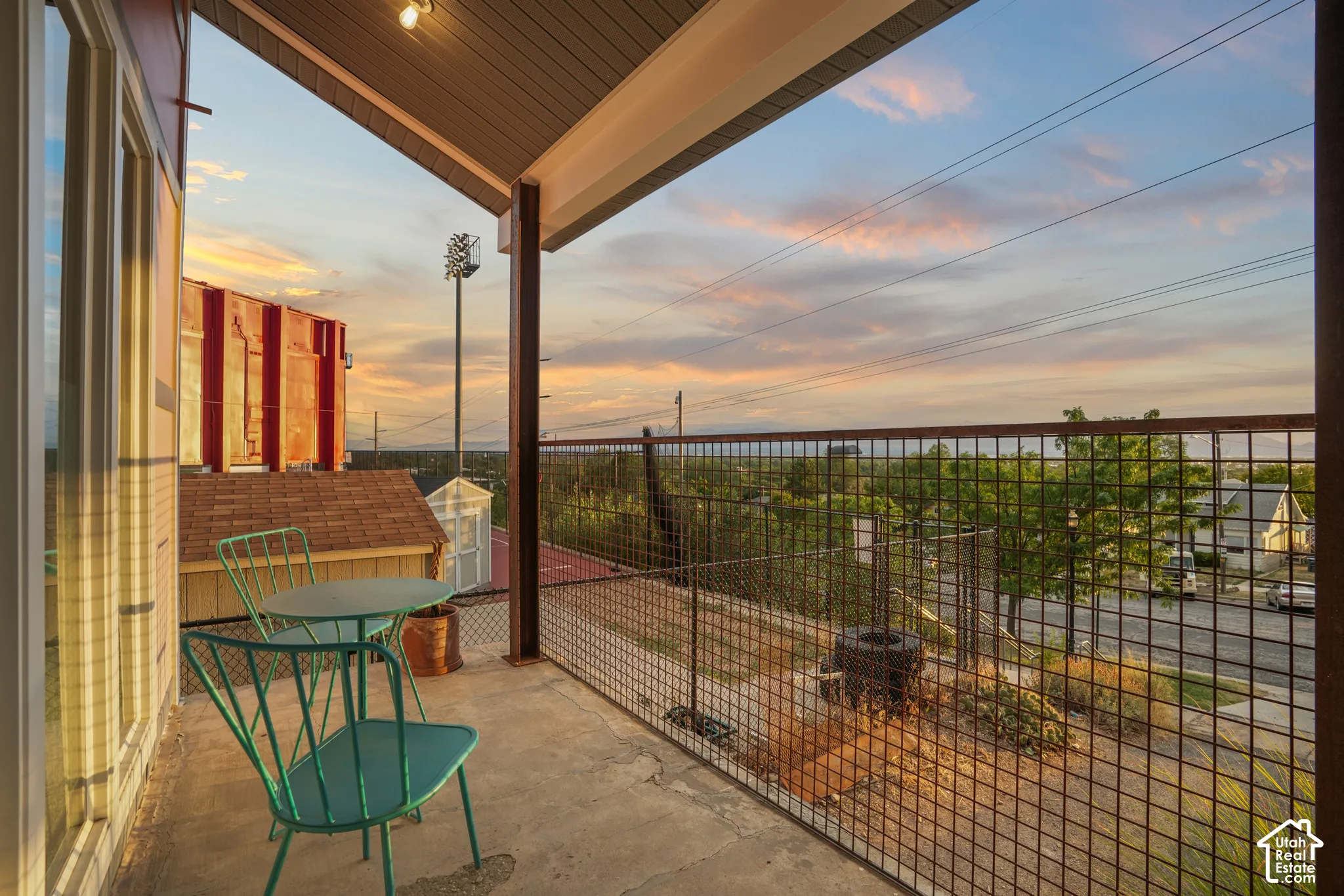 Covered balcony with concrete flooring, metal railing, and exposed structural beam