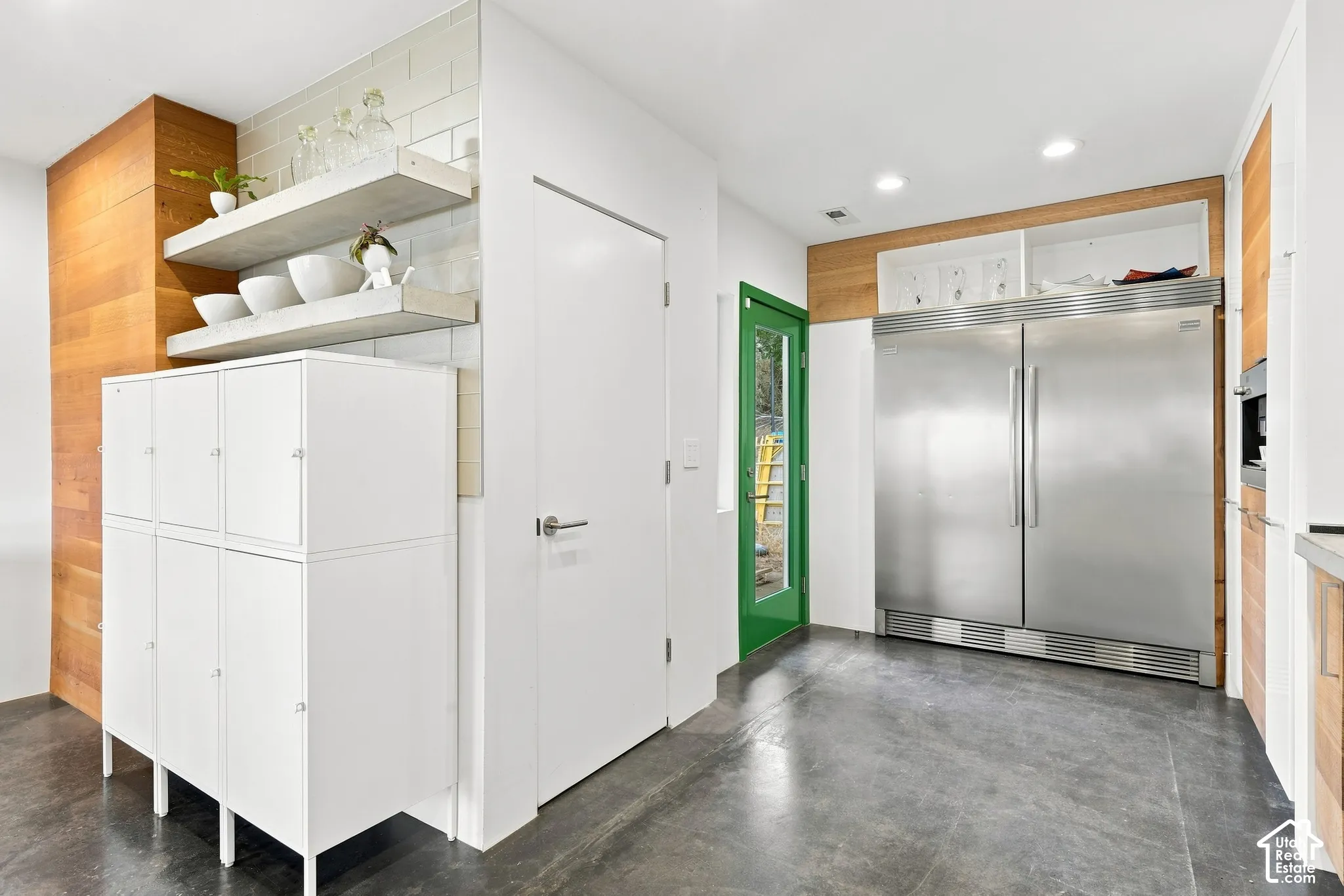 Polished concrete flooring, recessed lighting, and a stainless steel built-in refrigerator