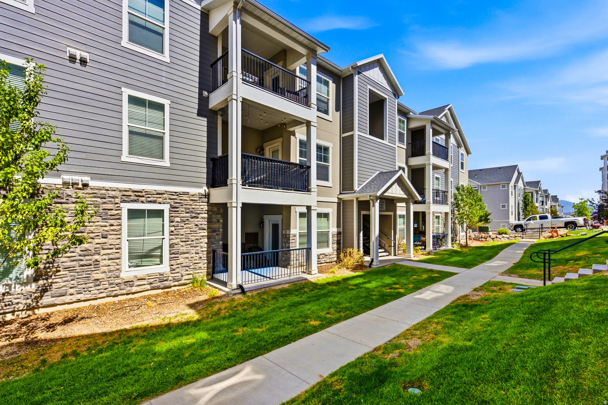 Multi-story residential buildings featuring horizontal siding and stone veneer accents