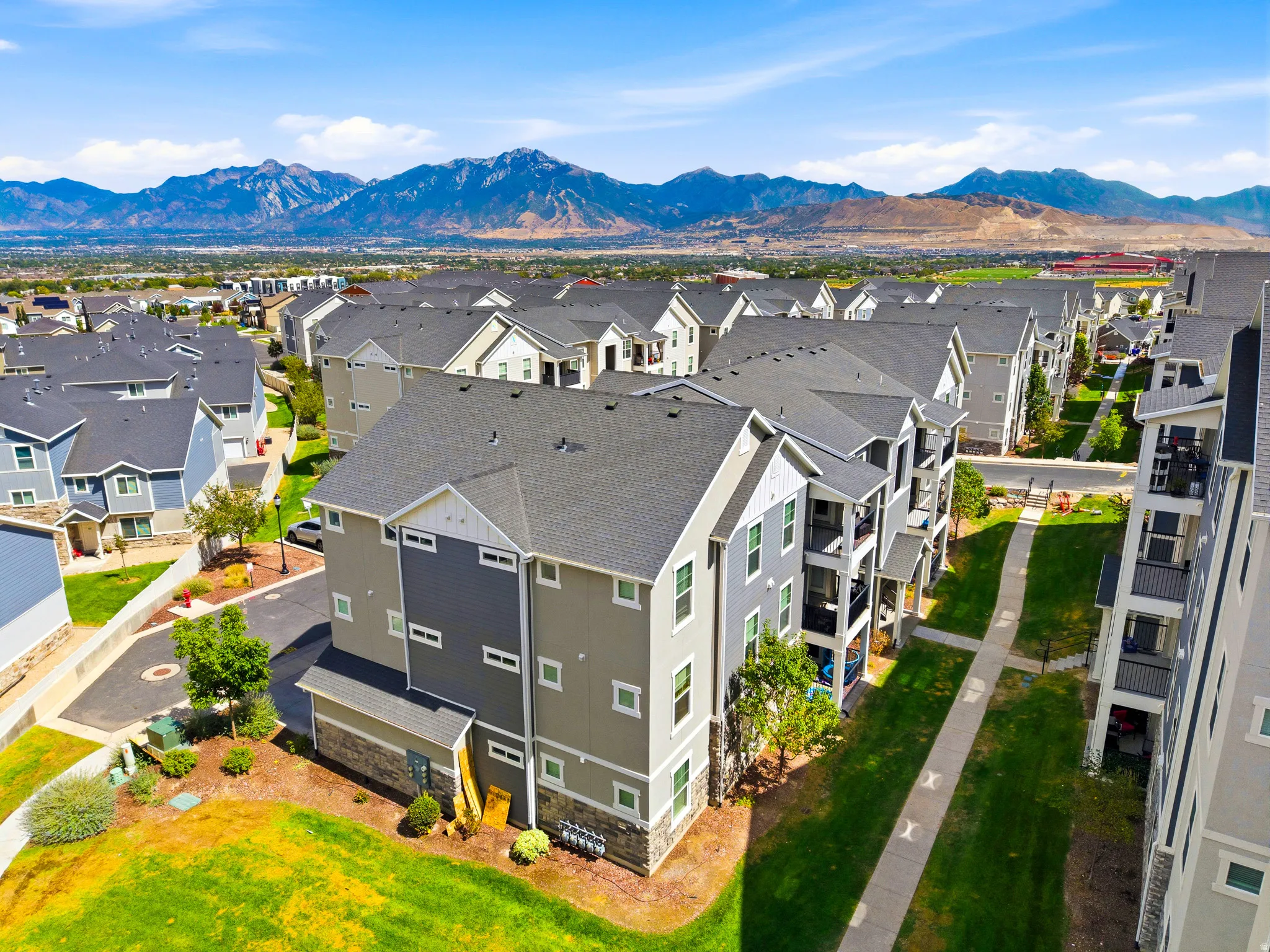 Modern multi-story residence featuring clean architectural lines, composite shingle roofing, and a contemporary color palette of gray and white exterior finishes