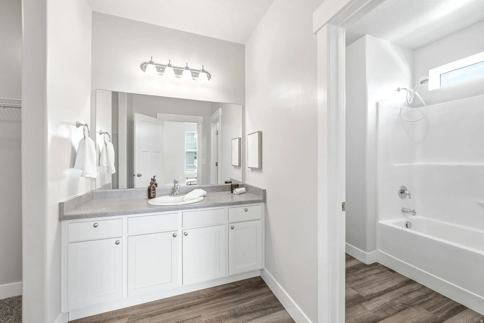 Bathroom vanity with white cabinetry, a gray countertop, and an undermount sink