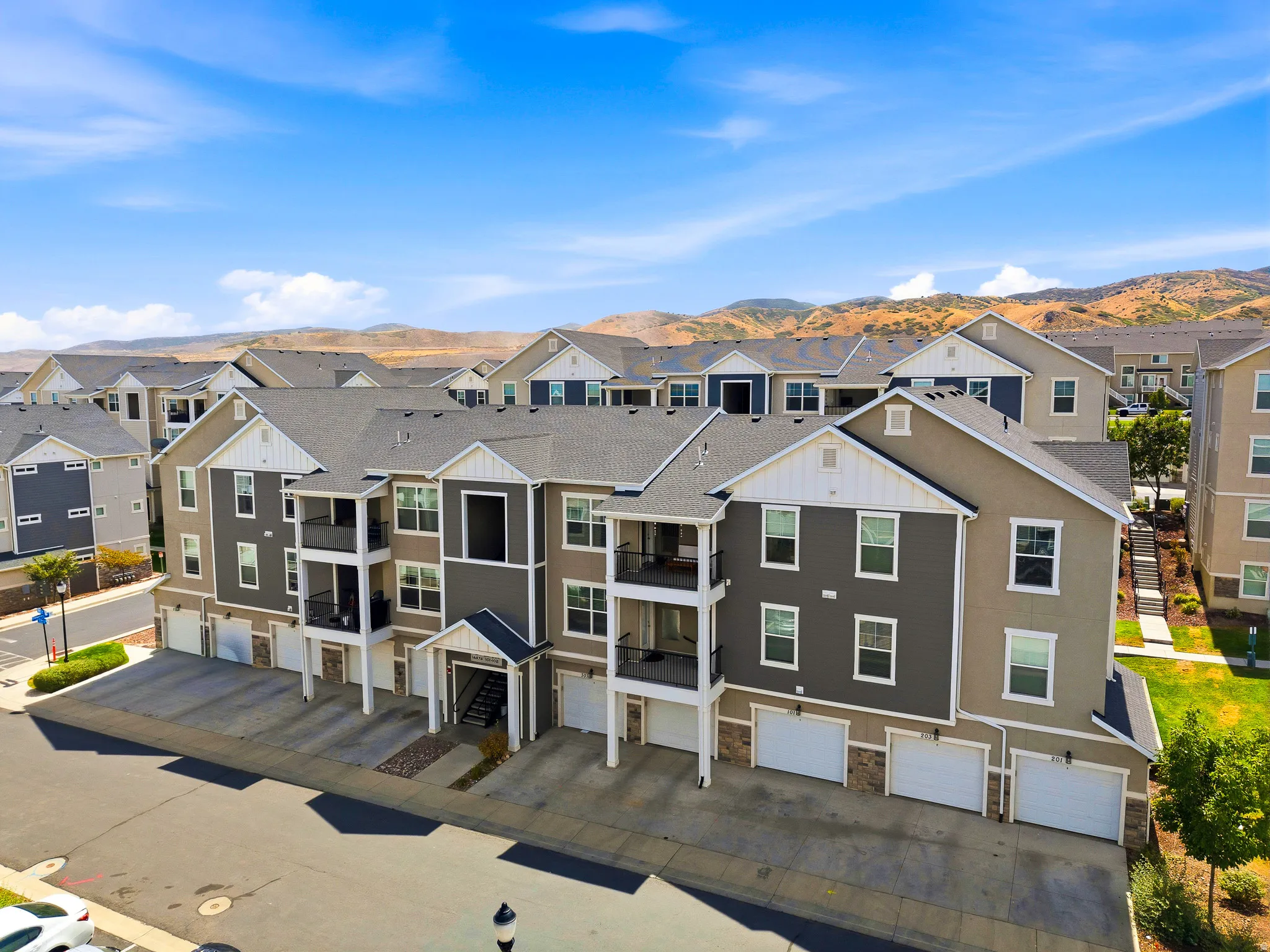 Modern multi-unit residential development featuring contemporary architectural design with mixed-tone exterior finishes in charcoal and neutral tones