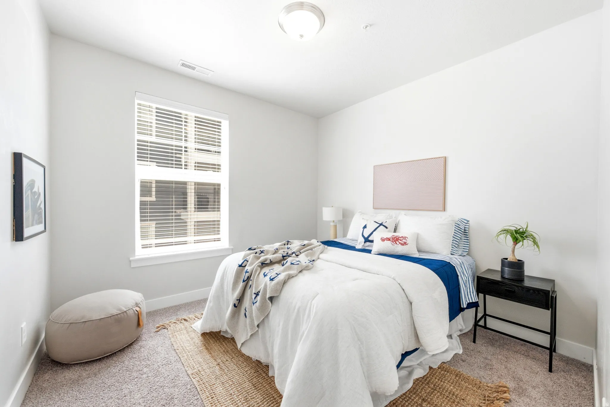 Bright secondary bedroom featuring large double-hung windows with plantation shutters, neutral wall finishes, and natural light