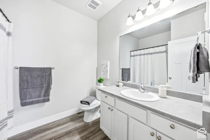Modern bathroom featuring a white vanity with dual sinks, quartz countertop, and polished chrome fixtures