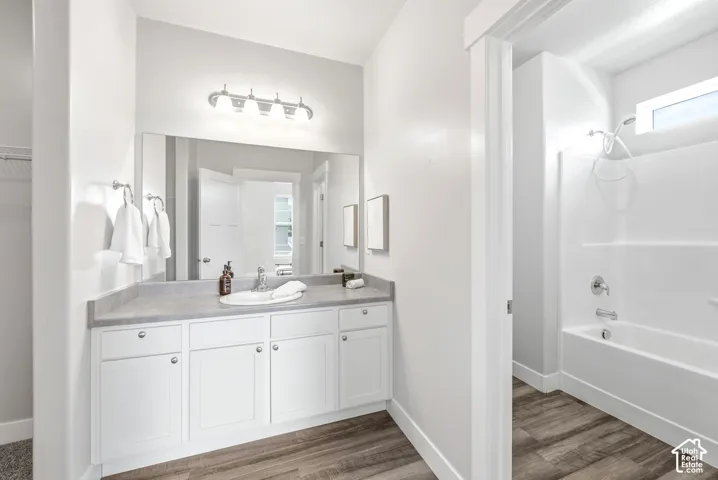 Bathroom vanity with white cabinetry, a gray countertop, and an undermount sink