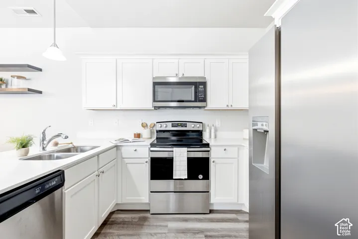 Modern kitchen featuring stainless steel appliances including a gas range with dual ovens, over-the-range microwave, and refrigerator with ice and water dispenser