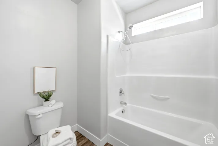 Clean and bright bathroom featuring a white subway tile shower surround with integrated shelf, chrome fixtures, and a pedestal sink