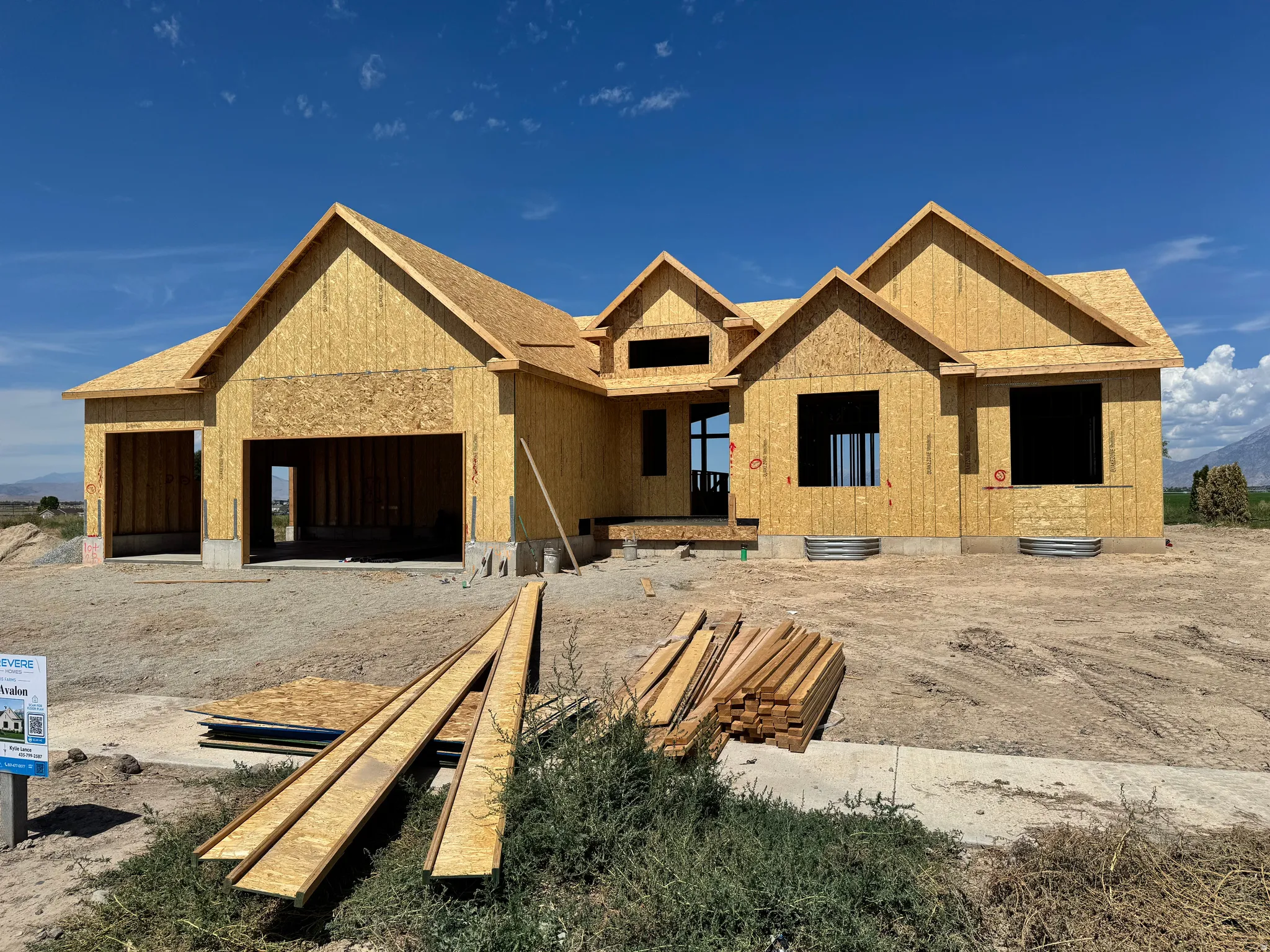 Under-construction residence with multiple gables, an integrated two-car garage, and a covered entry