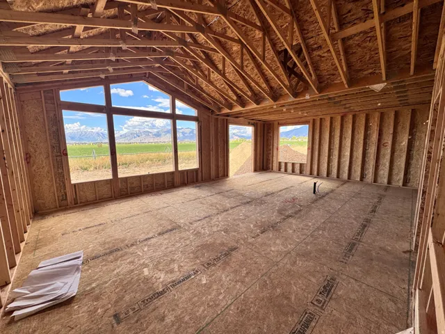 Expansive room with vaulted ceilings and exposed wood framing