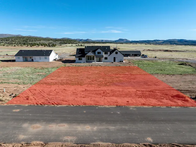 Spacious lot featuring a level terrain, paved road frontage, and open land beyond