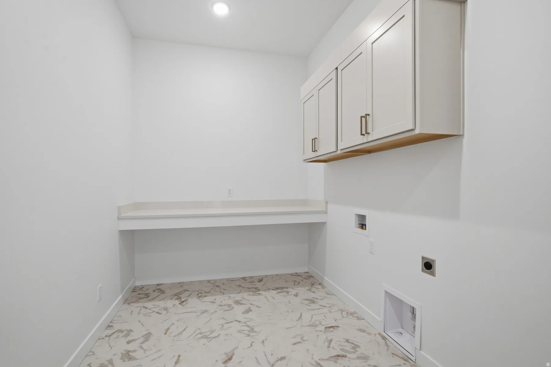 Recessed lighting, built-in cabinetry with bronze hardware, a light-toned countertop, and patterned floor tile
