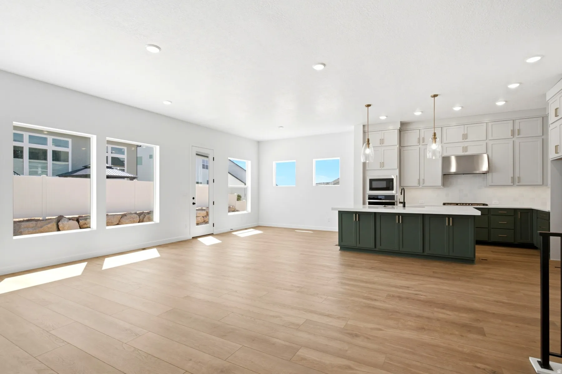 Kitchen featuring a central island with a white countertop and dark cabinetry, stainless steel appliances, and pendant lighting