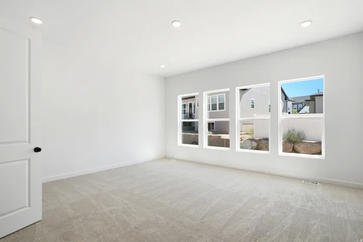 White walls with recessed lighting, light-toned carpet, and a series of four rectangular windows