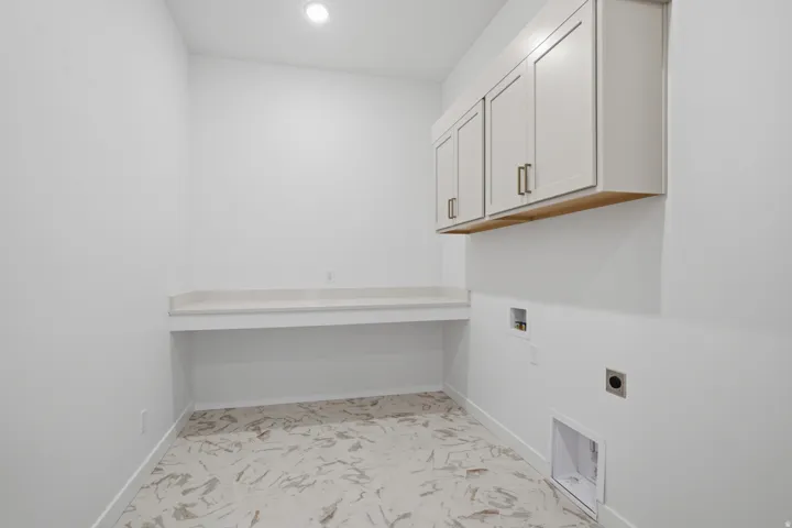 Recessed lighting, built-in cabinetry with bronze hardware, a light-toned countertop, and patterned floor tile