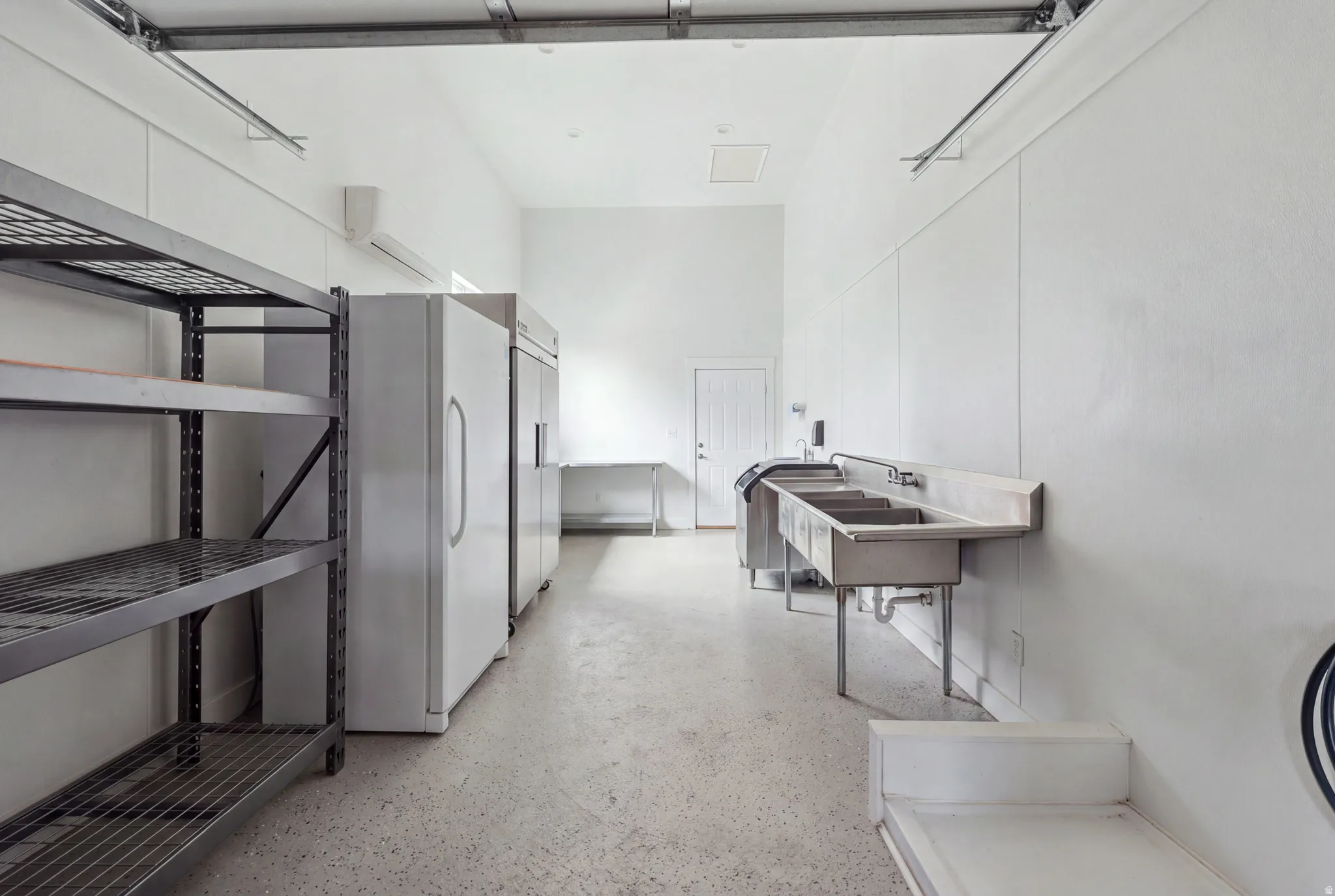 White walls, concrete flooring, and high ceilings