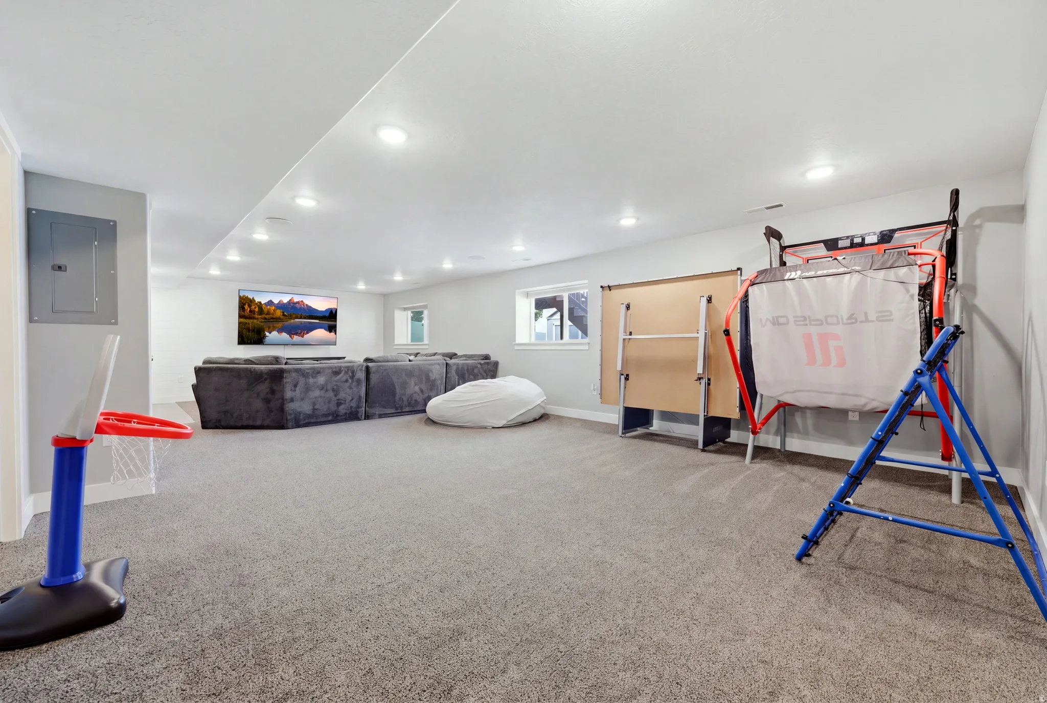 Recessed lighting illuminates the carpeted floor and painted walls