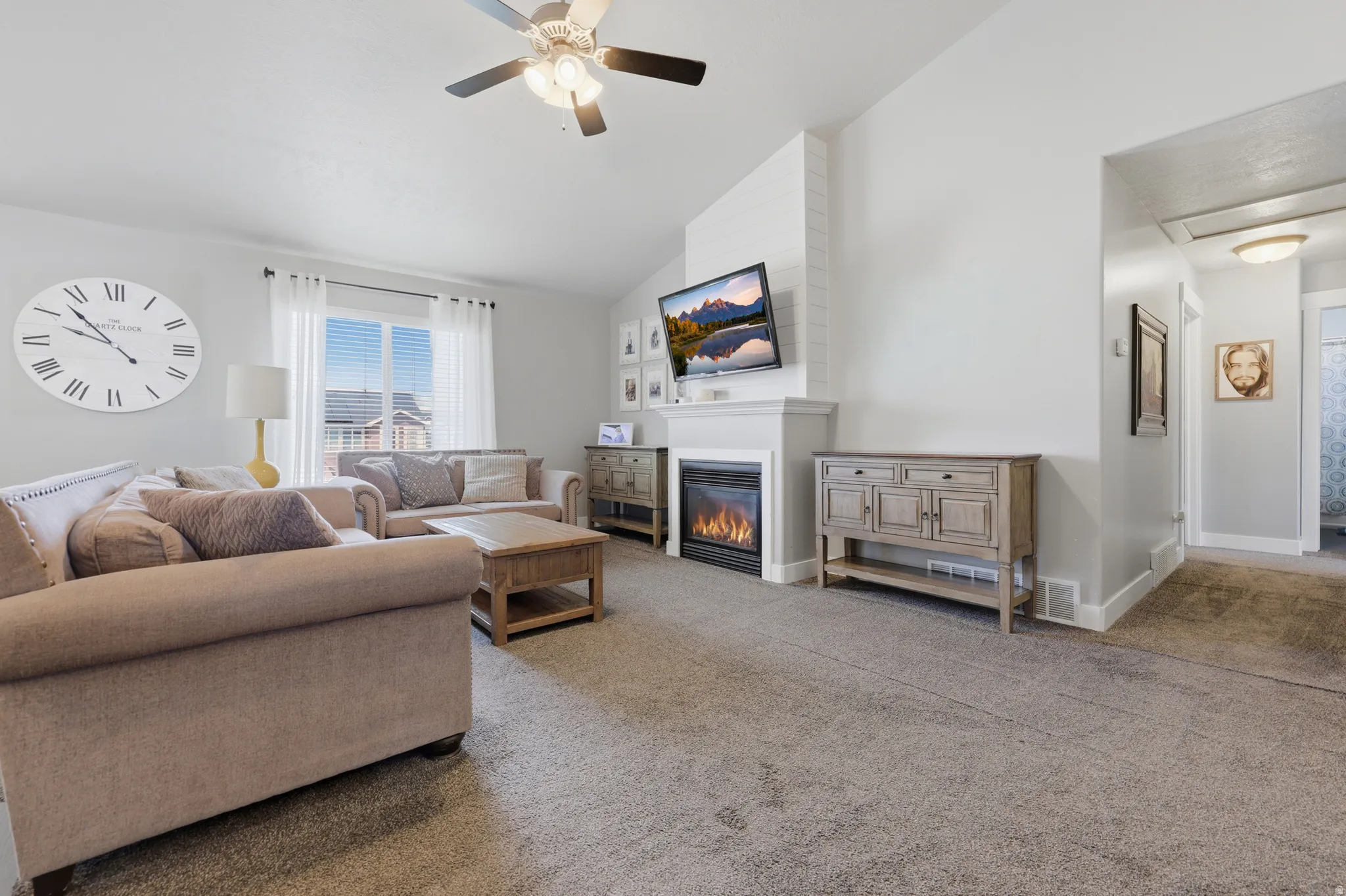 Vaulted ceilings enhance the living space, featuring a ceiling fan and recessed lighting