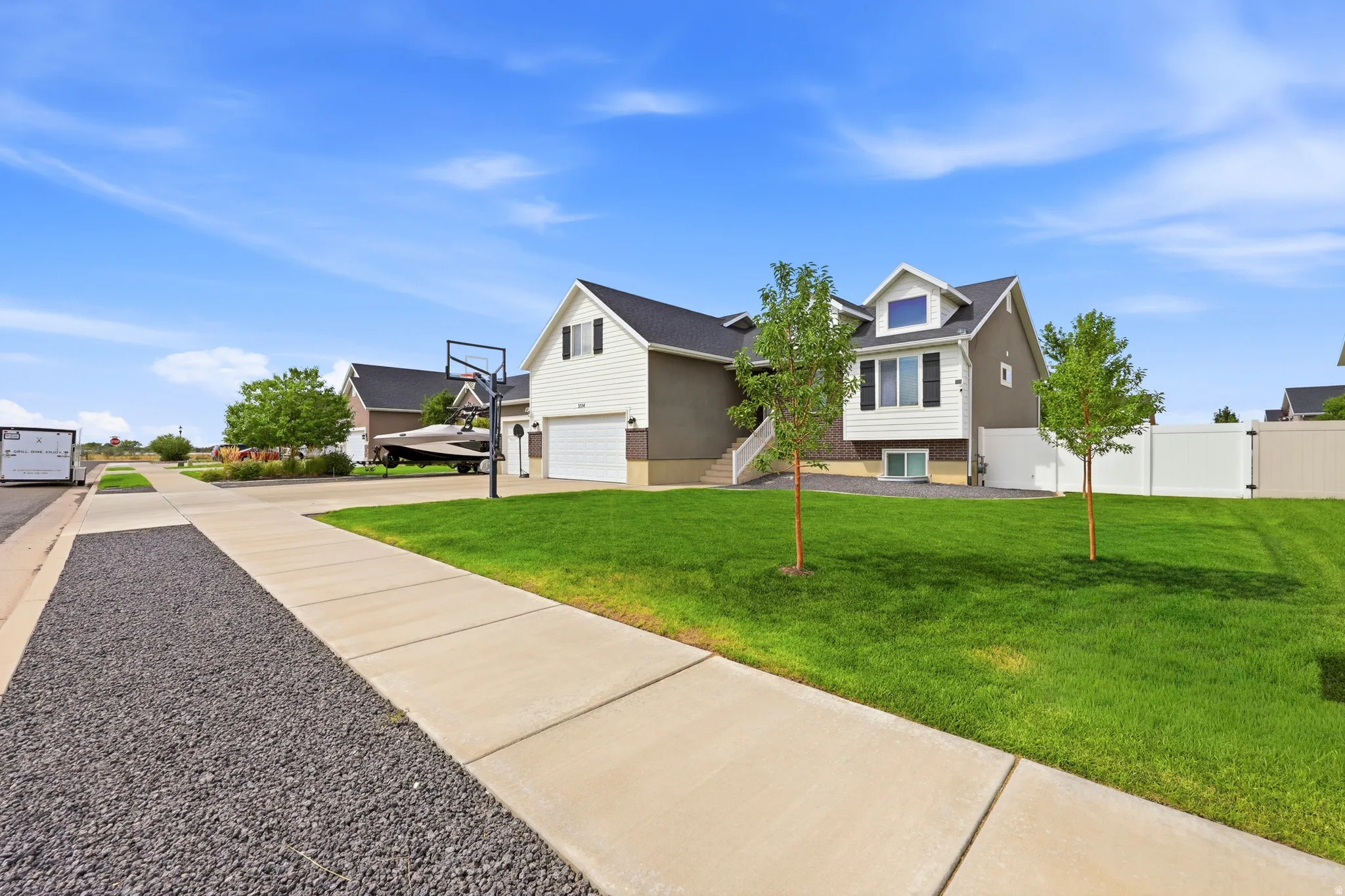 Modern two-story residence featuring a dormer window, dual-tone exterior siding, white trim, and a private fenced yard