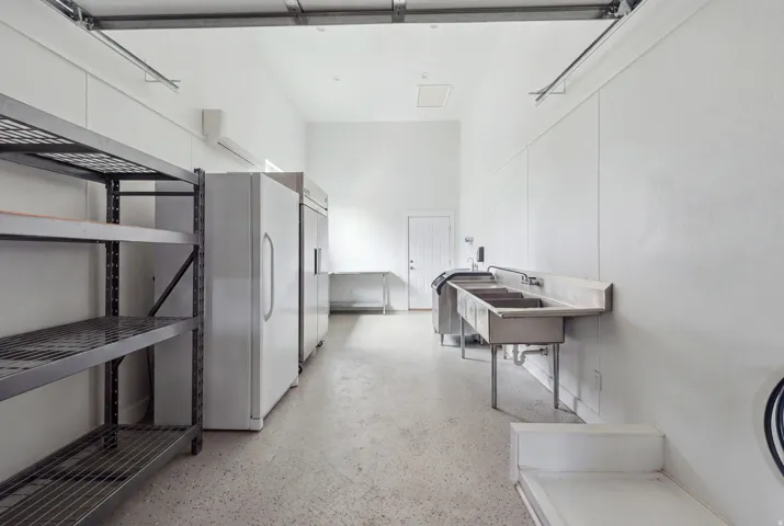 White walls, concrete flooring, and high ceilings