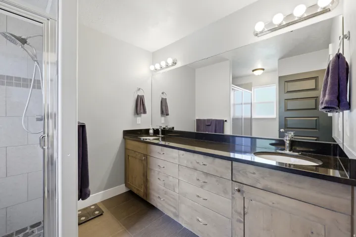 Dual vanity with dark countertops and integrated sinks