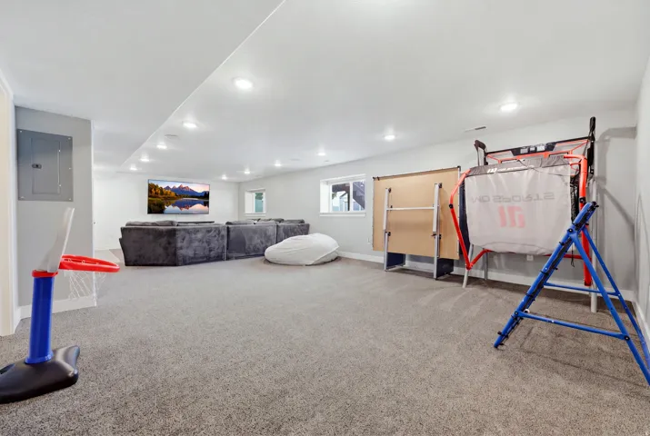 Recessed lighting illuminates the carpeted floor and painted walls