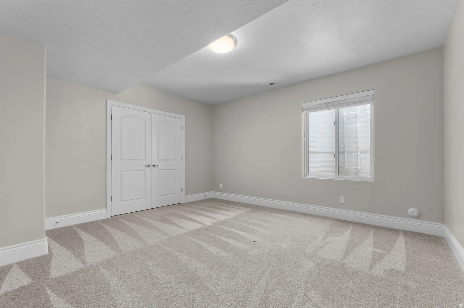 Recessed window, double-door entry, overhead lighting, carpet flooring, and white trim