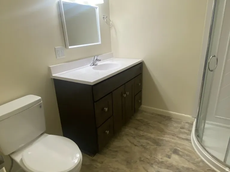 Vanity with a white countertop and integrated sink, chrome faucet, wall-mounted mirror, and three-light fixture