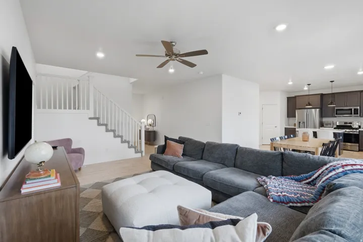 Open-concept living space featuring wood-finish flooring, recessed lighting, and a ceiling fan