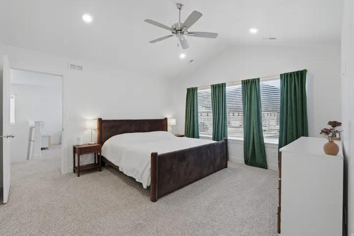 Vaulted ceiling, ceiling fan, recessed lighting, carpeted flooring, multiple windows with blinds