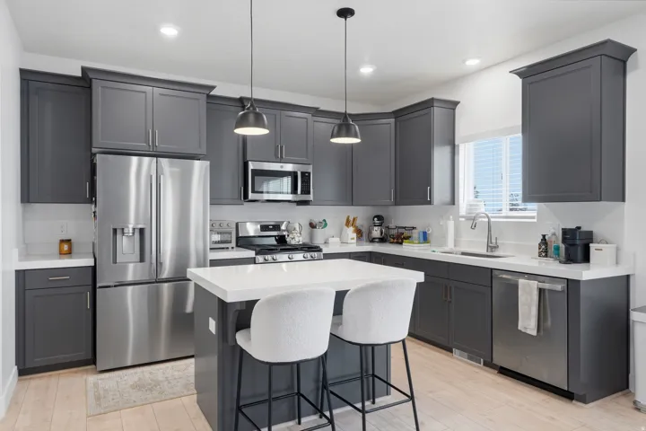 Modern kitchen featuring gray shaker-style cabinetry, stainless steel appliances, white countertops, and recessed lighting