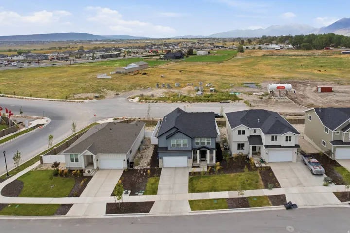 Newly constructed homes featuring modern two-story architecture with dark composite roofing, light-colored exterior siding, and attached two-car garages
