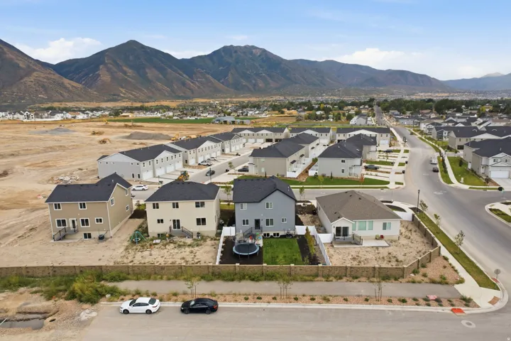 Mountain backdrop, residential area, new construction, paved roads, and sidewalks