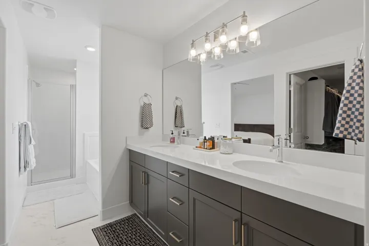 Dual vanity with undermount sinks, white countertop, dark wood-finish cabinetry, and chrome fixtures