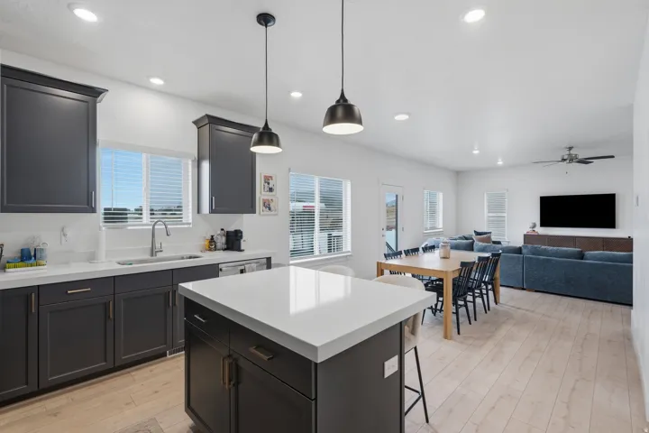 Open-concept living area featuring light wood-finish flooring, recessed lighting, and a ceiling fan