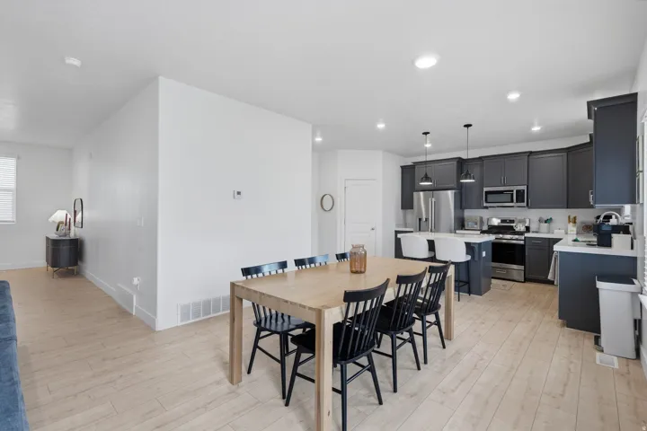 Modern kitchen featuring dark cabinetry, stainless steel appliances, and an island with seating
