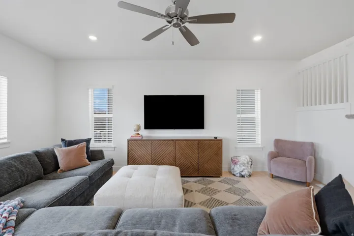 Recessed lighting and a ceiling fan illuminate this living space