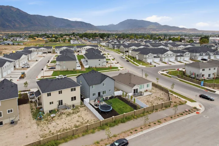 Residential development featuring multiple properties with dark shingle roofs and light-toned siding