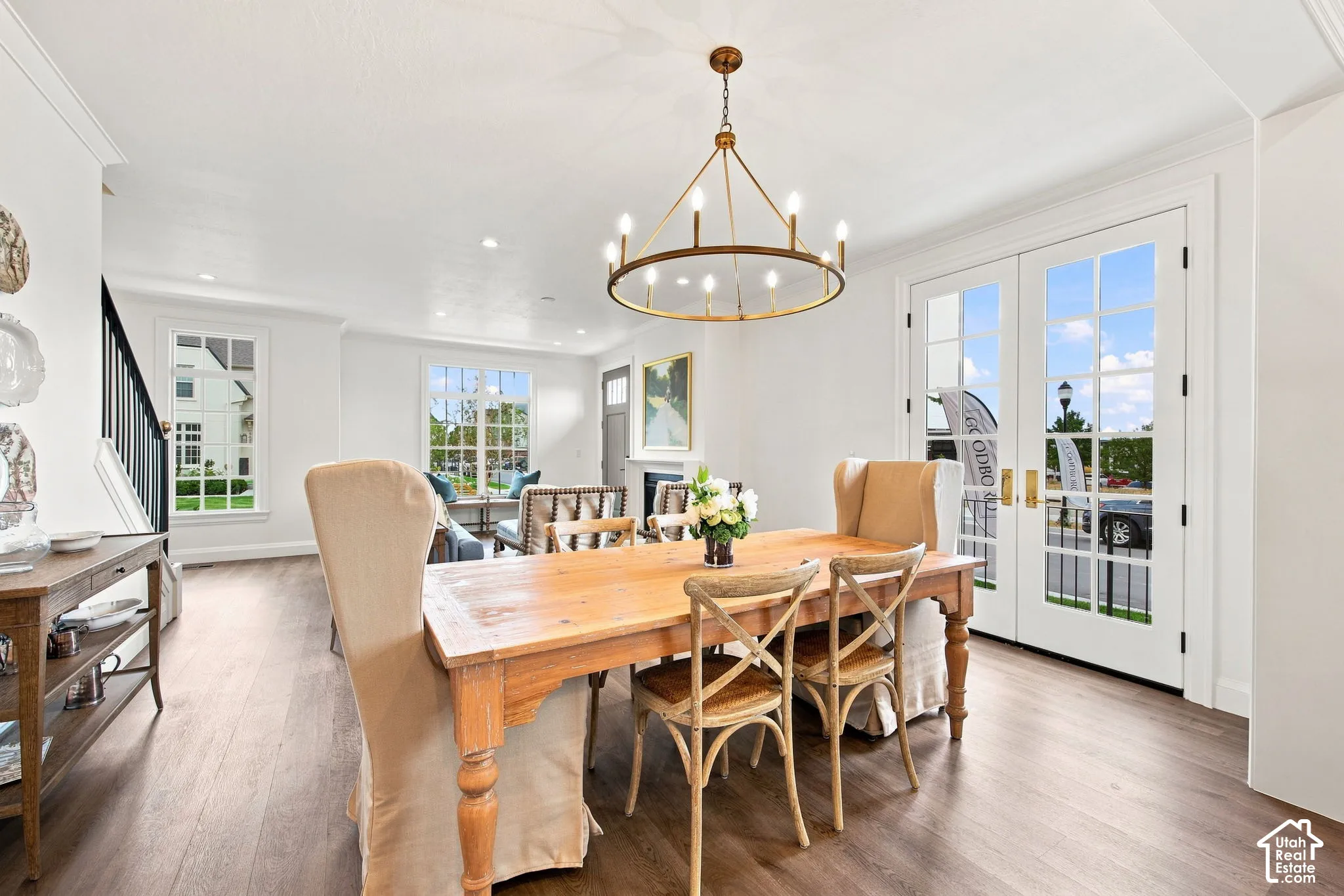 Model Home - Spacious dining area featuring wood-finish flooring, a brass chandelier, and French doors