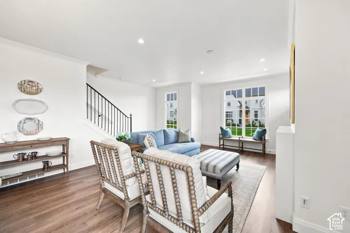 Model Home - Wood-finish flooring, recessed lighting, crown molding, a staircase with a wrought iron railing, and large multi-pane windows
