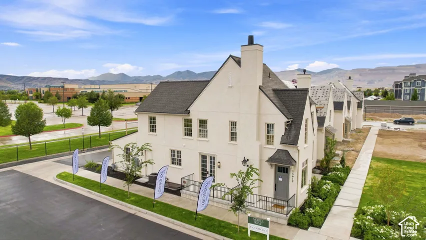 Model Home - Stucco exterior with prominent chimney stack, multi-pane windows, and a dark shingle roof