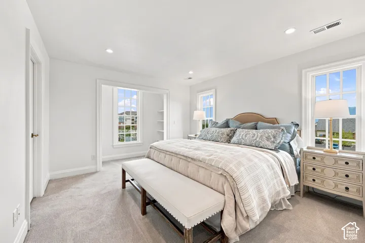 Model Home - Recessed lighting, light-toned carpeting, multiple windows, and a built-in shelving unit
