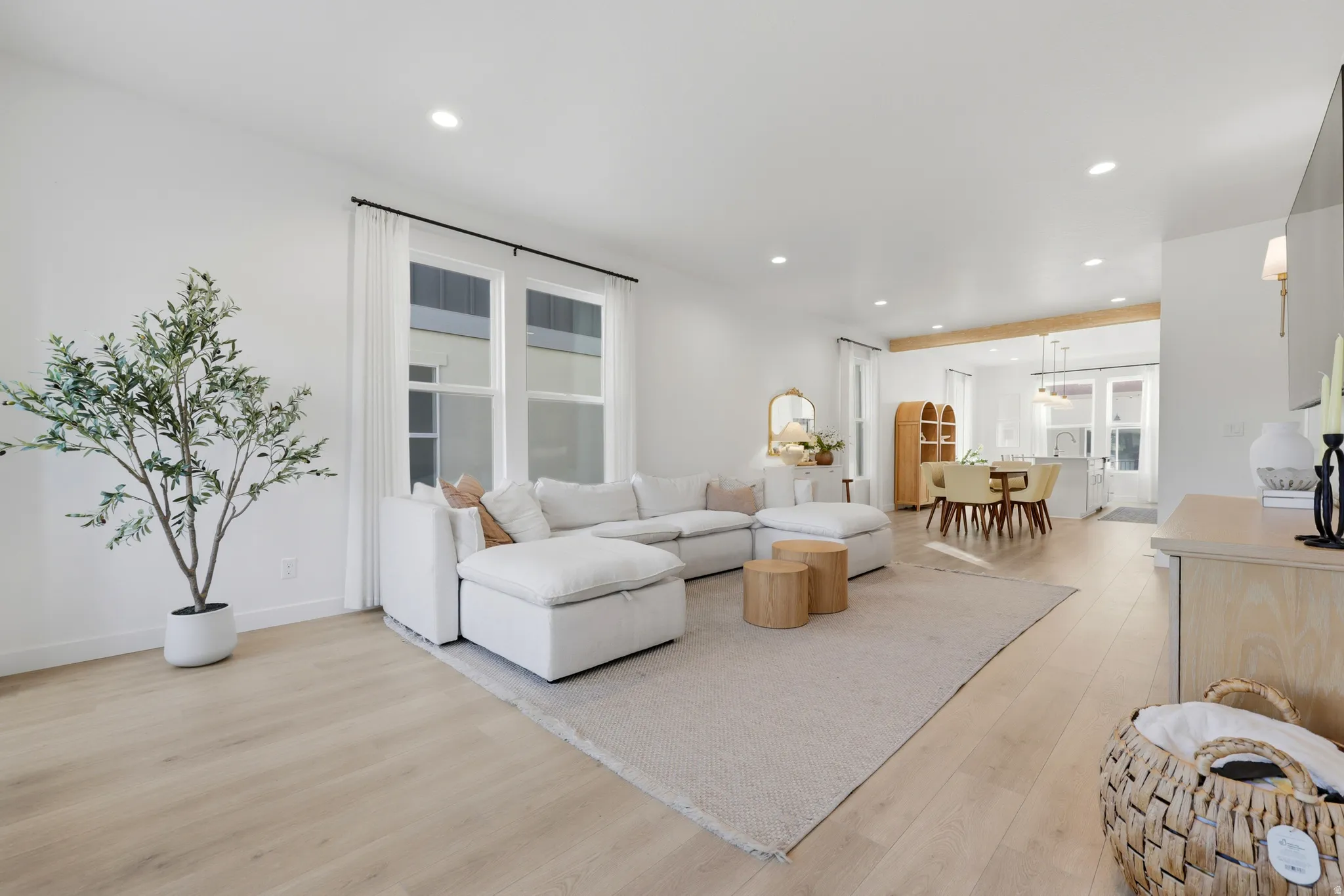 Recessed lighting, wood-finish flooring, multiple large windows, and an open-concept design