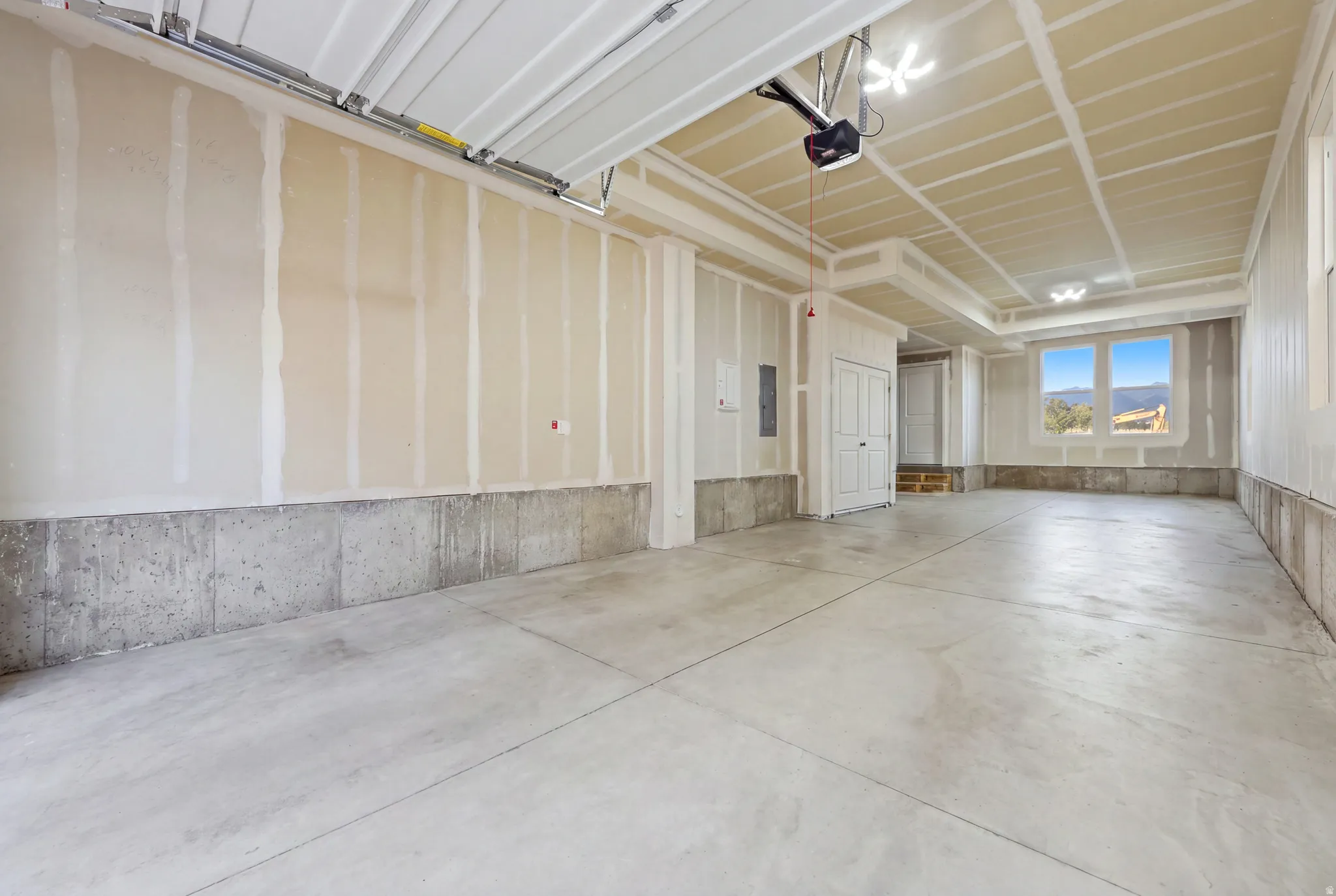 Expansive garage featuring concrete flooring, an automatic garage door opener, and a rear window
