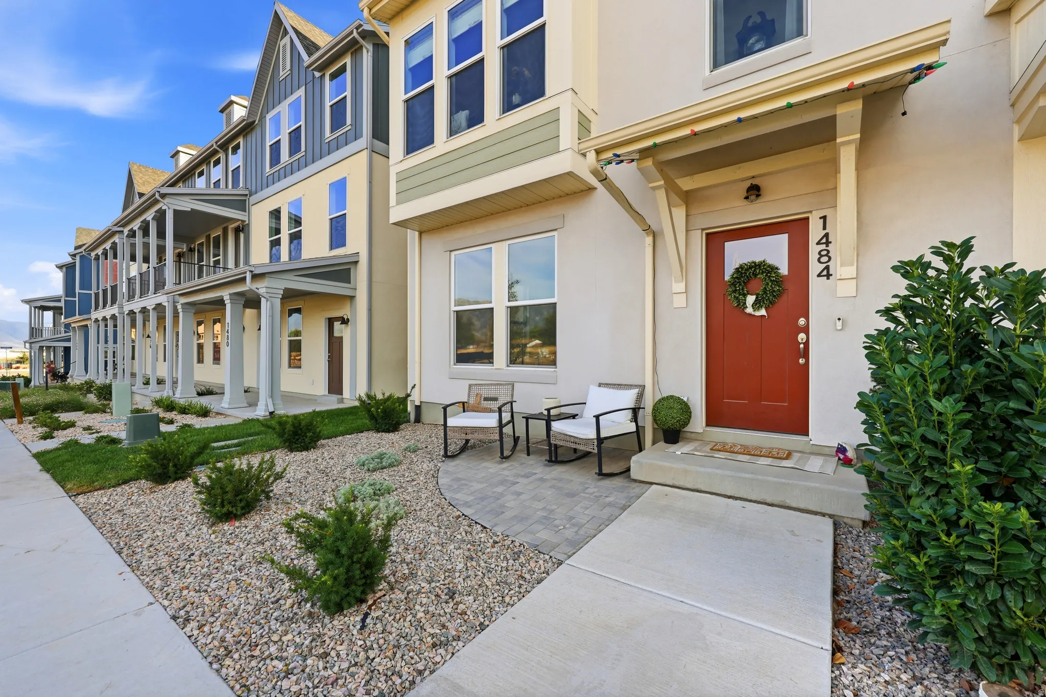 Stucco exterior with a contrasting red front door and transom window