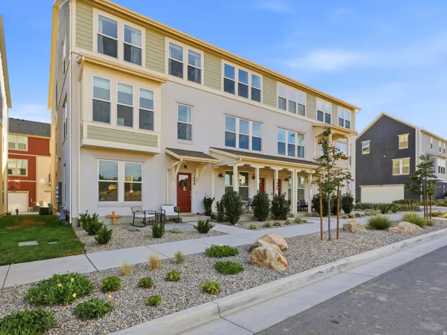 Multi-level townhome featuring a neutral stucco exterior with decorative siding accents