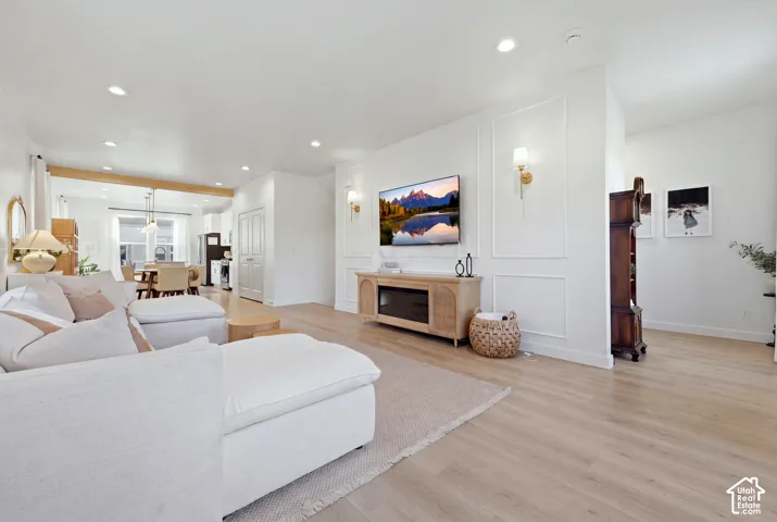 Recessed lighting, light wood-finish flooring, and white walls