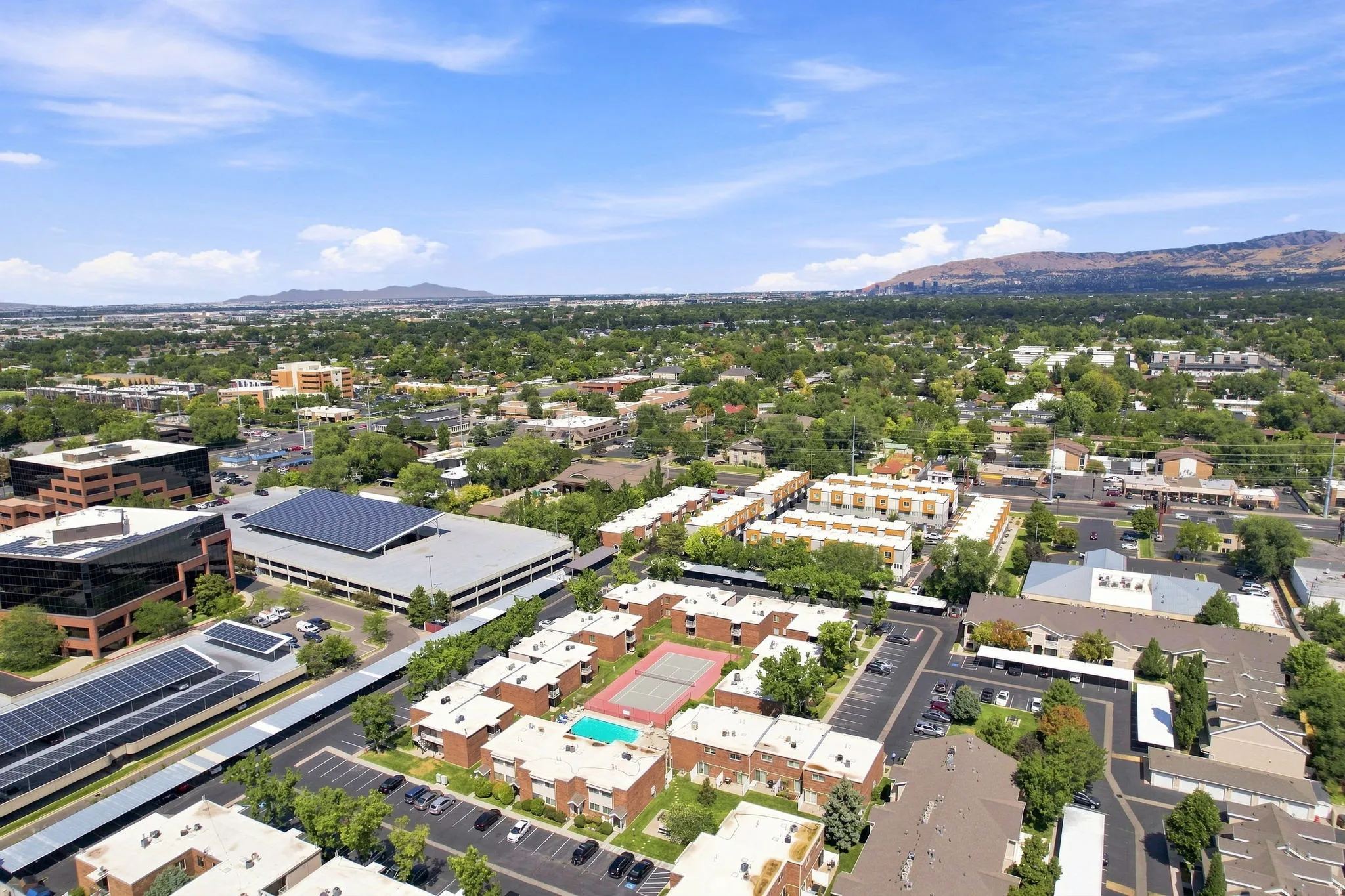 Expansive urban landscape with abundant tree canopies and distant mountains