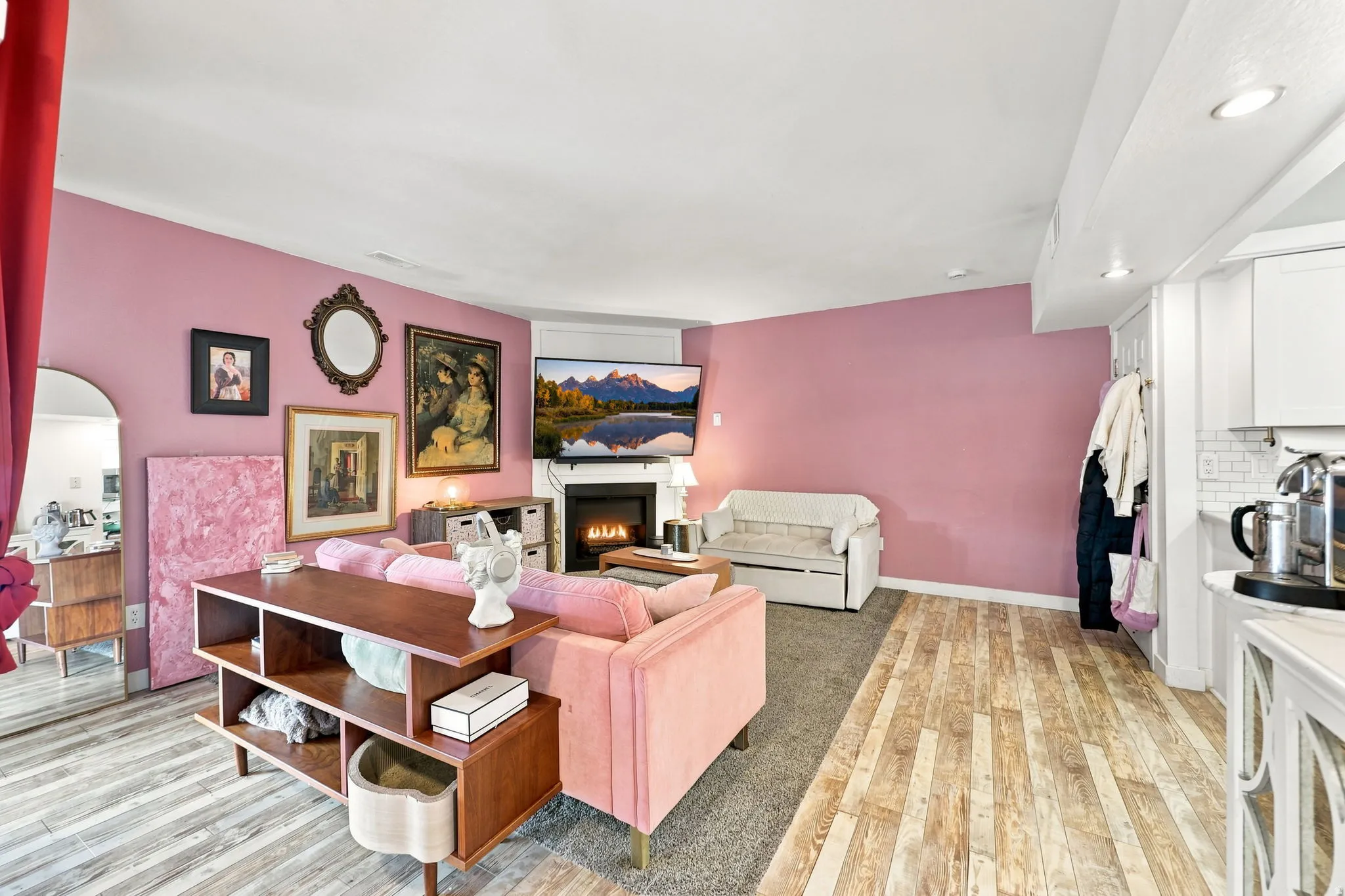 Living area featuring a white fireplace with a mantel, recessed lighting, and wood-finish flooring