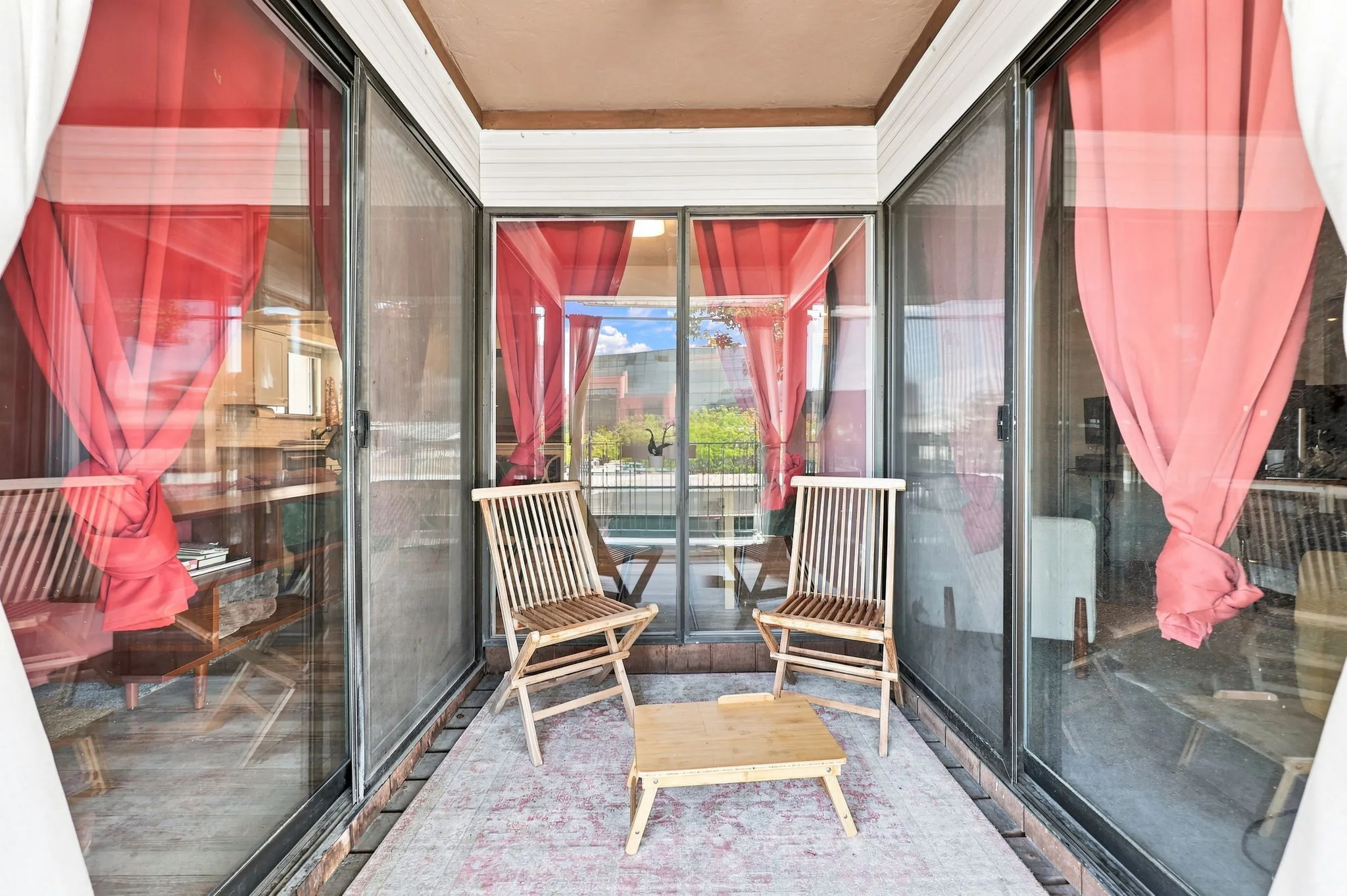 Enclosed balcony featuring multiple sliding glass doors and a neutral-toned ceiling