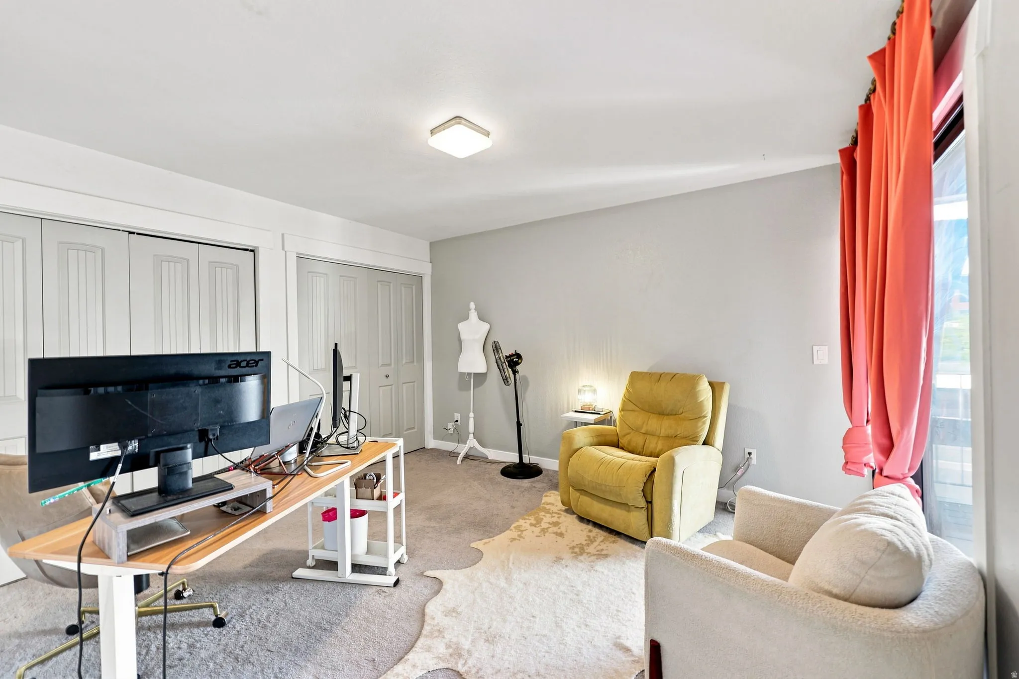 Carpeted interior with light gray wall paint, two white bi-fold closet doors, and white trim molding
